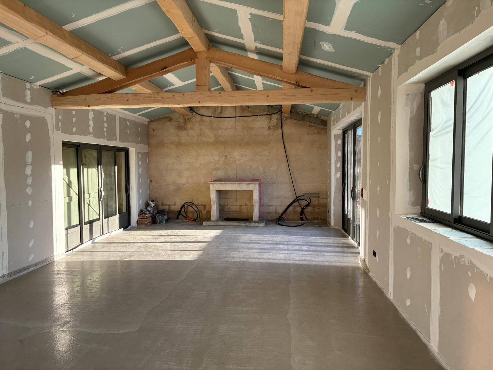 Rénovation d'une pièce avec charpente et cheminée en pierre
